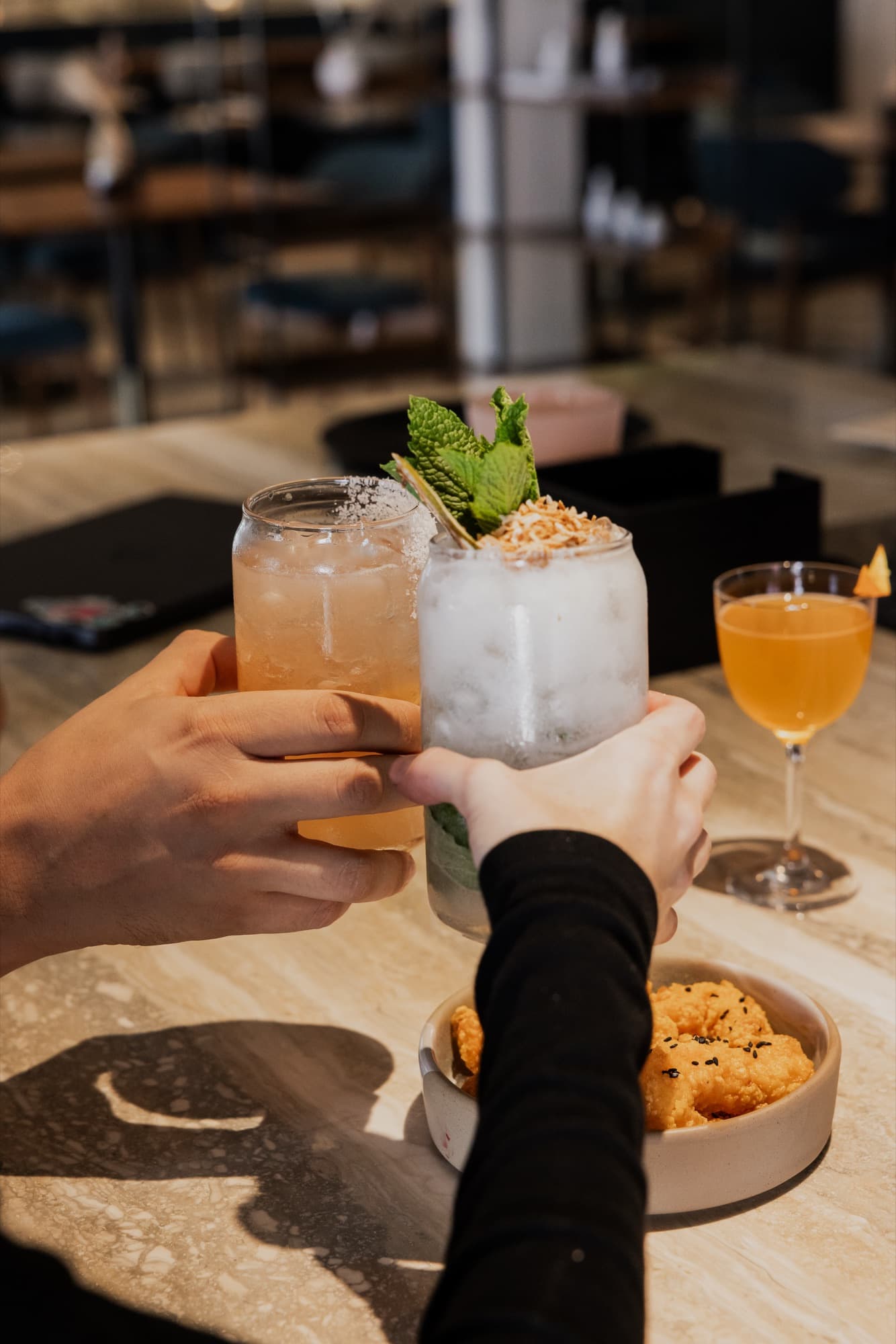Two guests toasting with cocktails at Cotidiano