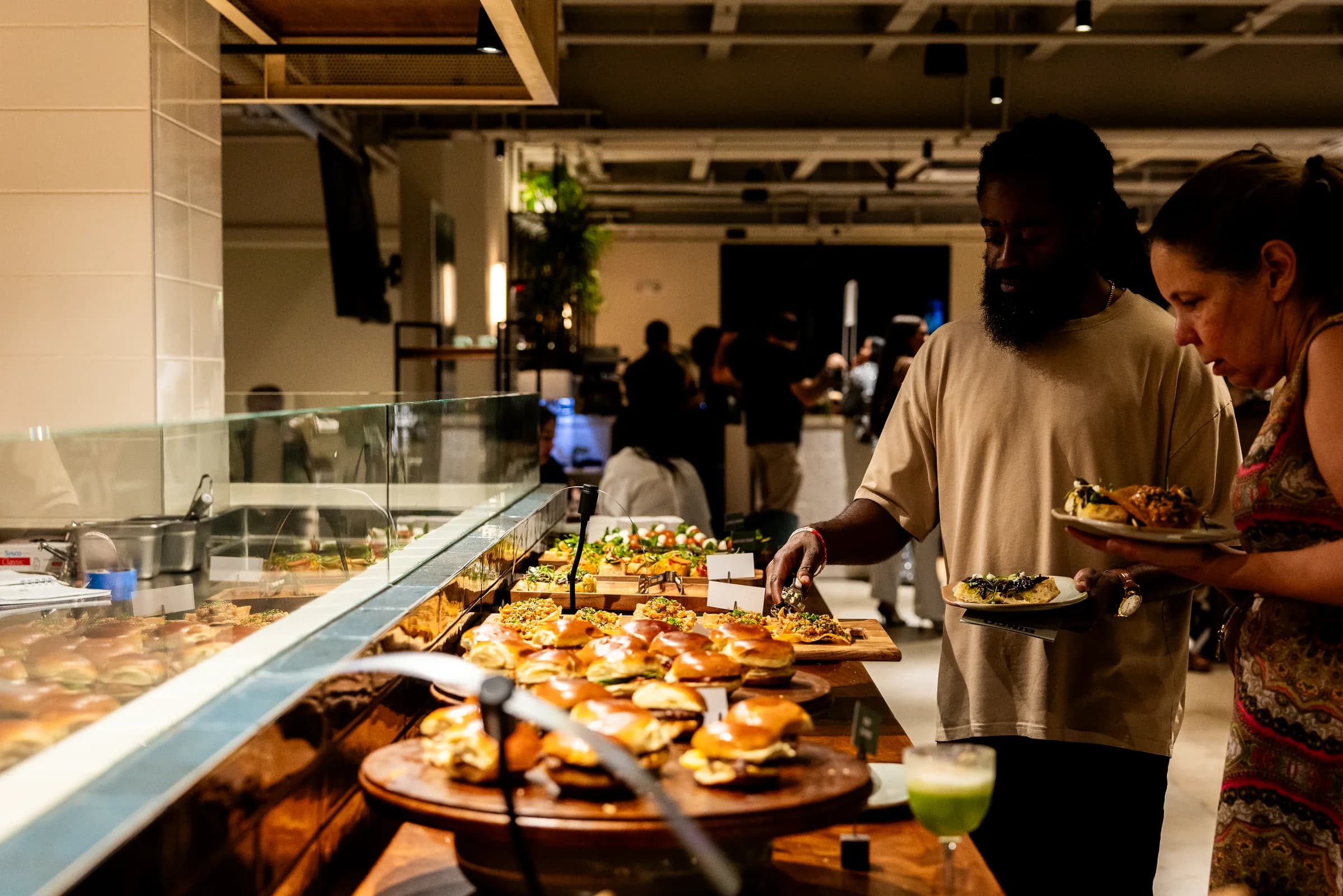 Guests choosing shared bites at a Cotidiano event