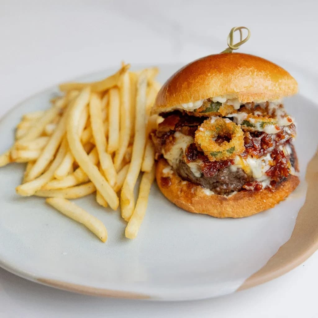 Cotidiano's sirloin burger with melted cheese, bacon jam, crispy jalapenos and fries