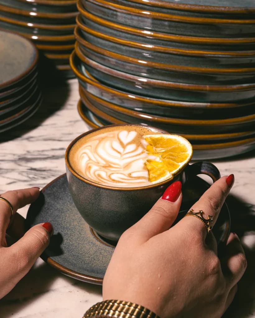 Latte art in a black ceramic cup at Cotidiano