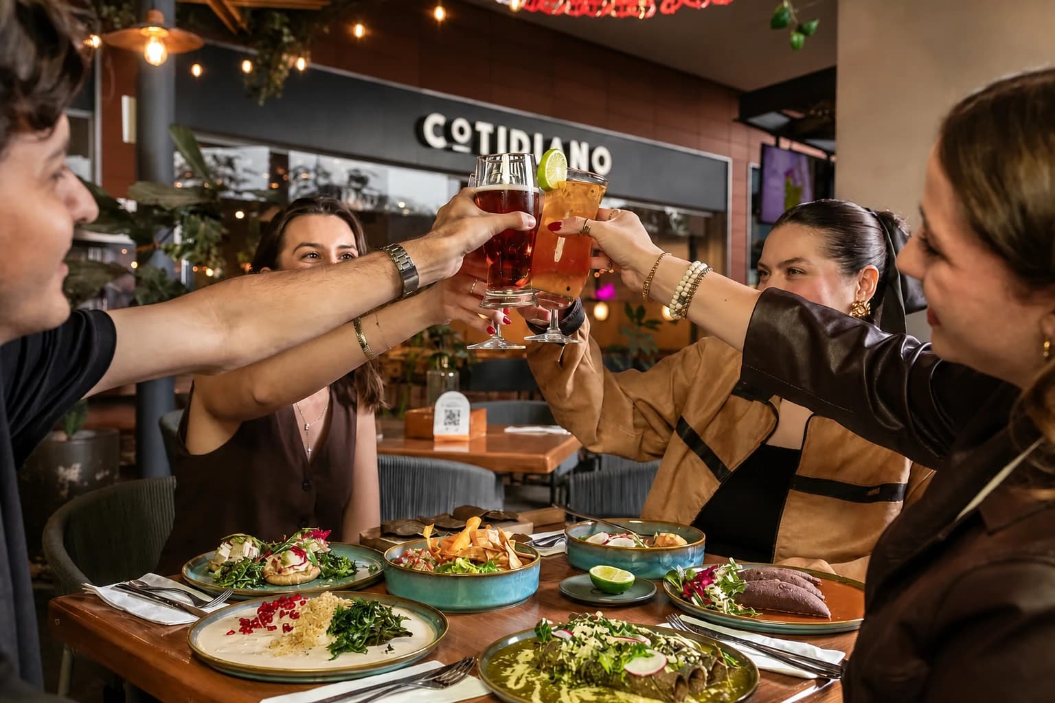 Friends raising a toast over a shared meal at Cotidiano