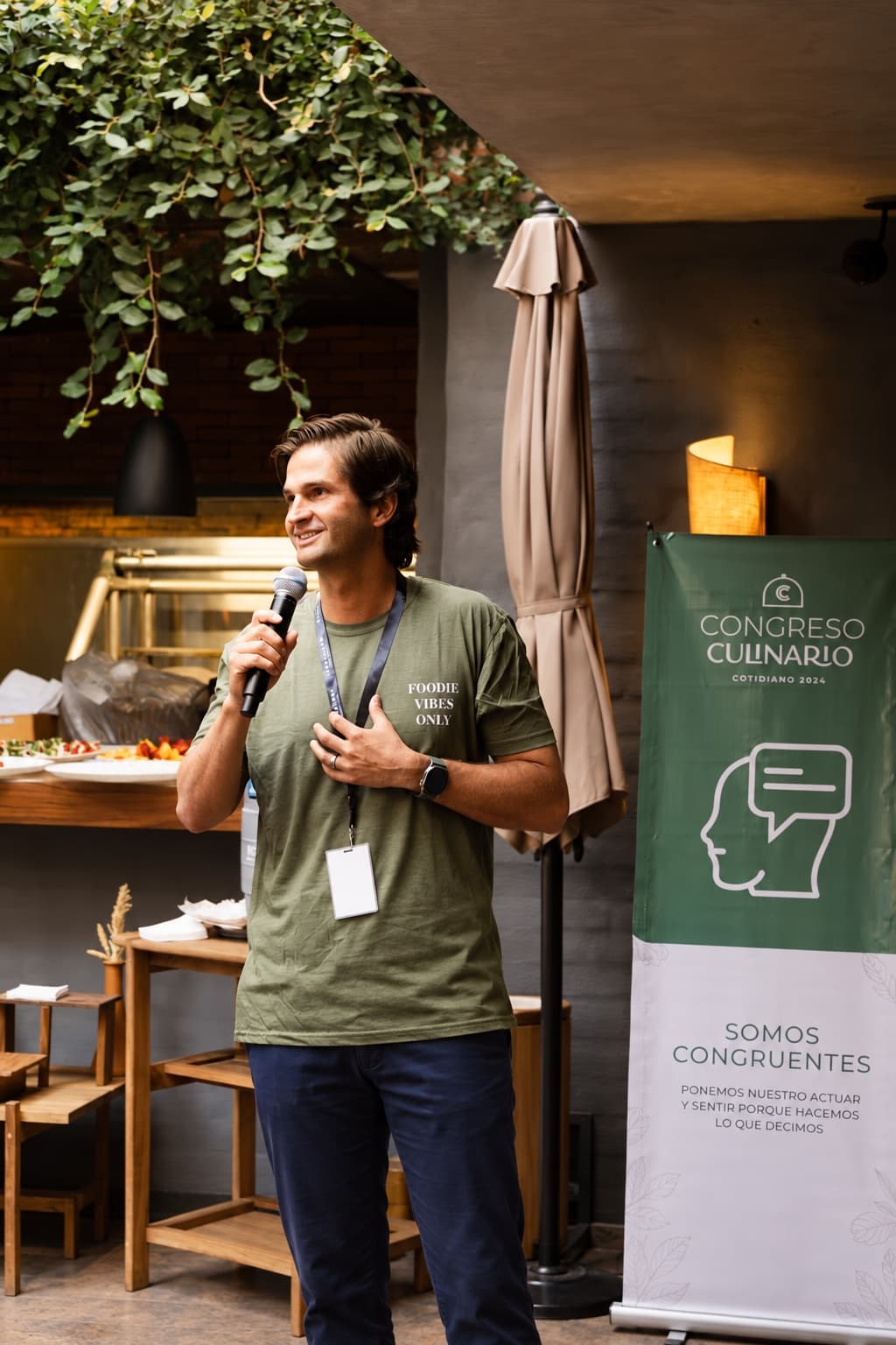 Rodrigo Hecht, founder of Cotidiano, speaking into a microphone at a culinary gathering
