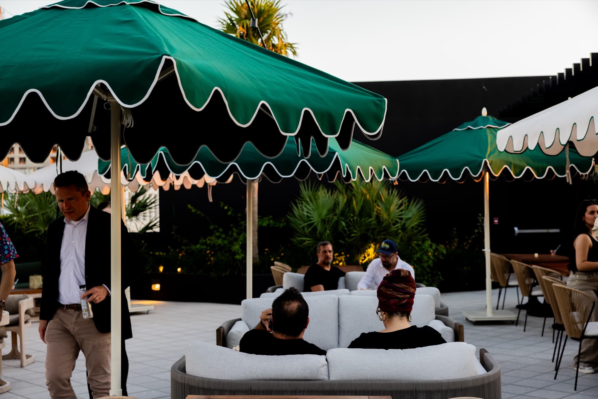 Guests mingling on Cotidiano's rooftop terrace in the evening